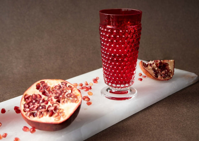 Underlay Garnet Hobnail Goblet (set of 2 pieces) surrounded by fruit on a black background