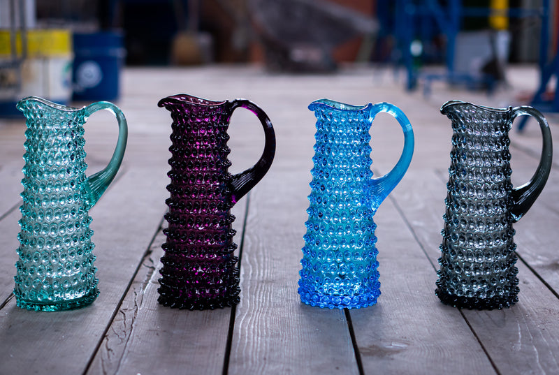 Beryl, Violet, Azure and Grey Glass Jugs standing next to each other on the Wooden Floor