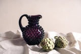 Violet Hobnail Jug Small on light grey fabric with artichokes and off-white flond
