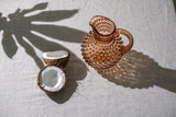 Bronze Hobnail Jug on the table with coconuts