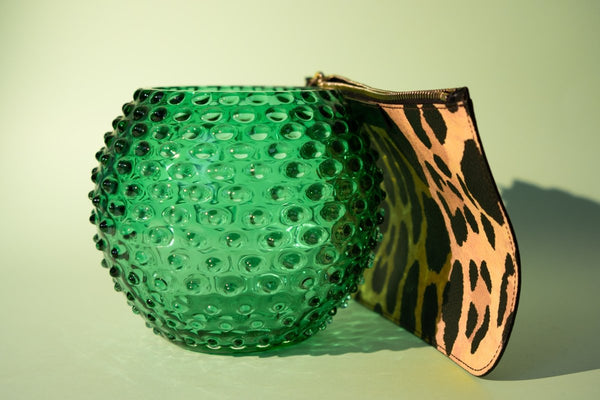 Underlay Dark Green Hobnail Vase with a leopard print pouch and white background 